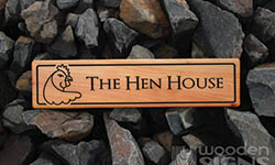wooden sign the hen house wtih carved chicken head on the left hand side